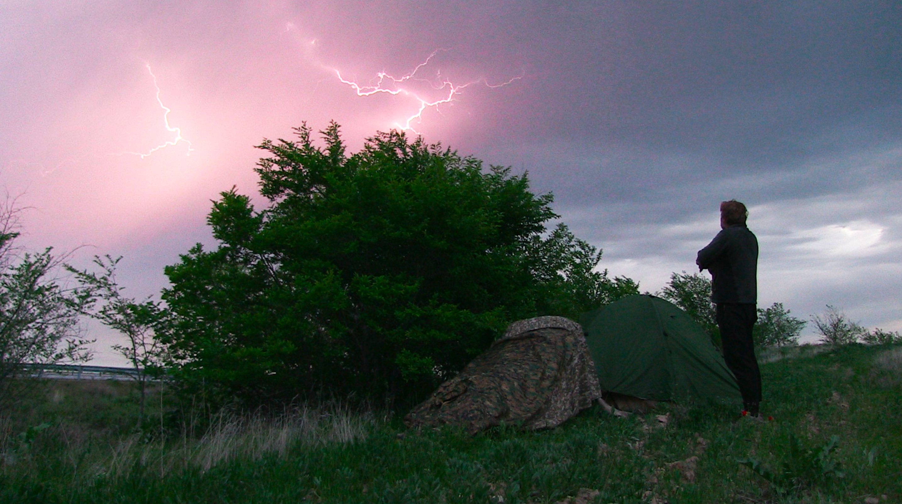 Karl watching a lightning storm from beside his tent in Kazakhstan, 2019